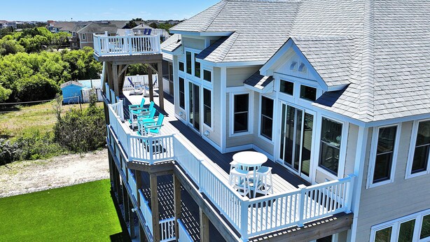 A multi-story house with a balcony, a deck, and a large window. - Oceanside, Private Pool, ELEV, Hot Tub Rec Room, yard, SUN-SUN, WW865-This One's for You! (Corolla)