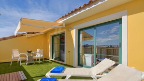 A sunlit patio with two lounge chairs, a small table, and chairs, a tiled floor, and a glass door leading to a balcony. - Sorolla Sol - Javea, Costa Blanca (Javea)