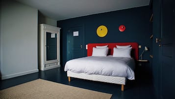 A bedroom with a bed, a door, and a wall with a circular decoration.