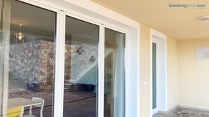 A modern interior with a stone wall, a staircase, and a glass door leading to an outdoor area.