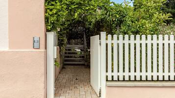 A gated entrance with a brick pathway leading to a covered area.