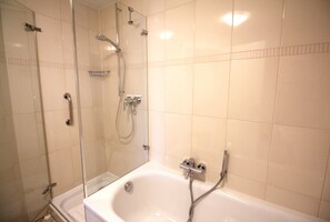 Ein Badezimmer mit Badewanne, Dusche und einer separaten Duschkabine.