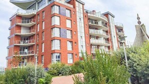 Ein mehrstöckiges Wohngebäude mit Balkonen, einer Ziegel-Fassade und einem unverwechselbaren architektonischen Design.
