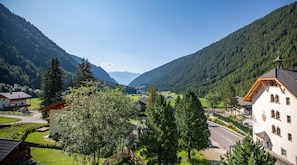 A mountain village with traditional architecture, a road, and a valley.