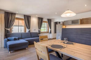 Un salon moderne comprenant un canapé, une table à manger et un coin cuisine.