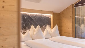 Un dormitorio de cabaña de madera con una cama, almohadas y un cartel con un paisaje montañoso en la pared.