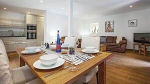 Un espace de vie moderne comprenant un coin repas, une cuisine et un coin salon.