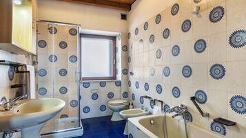 Ein Badezimmer mit Waschbecken, Toilette, Bidet und Badewanne.