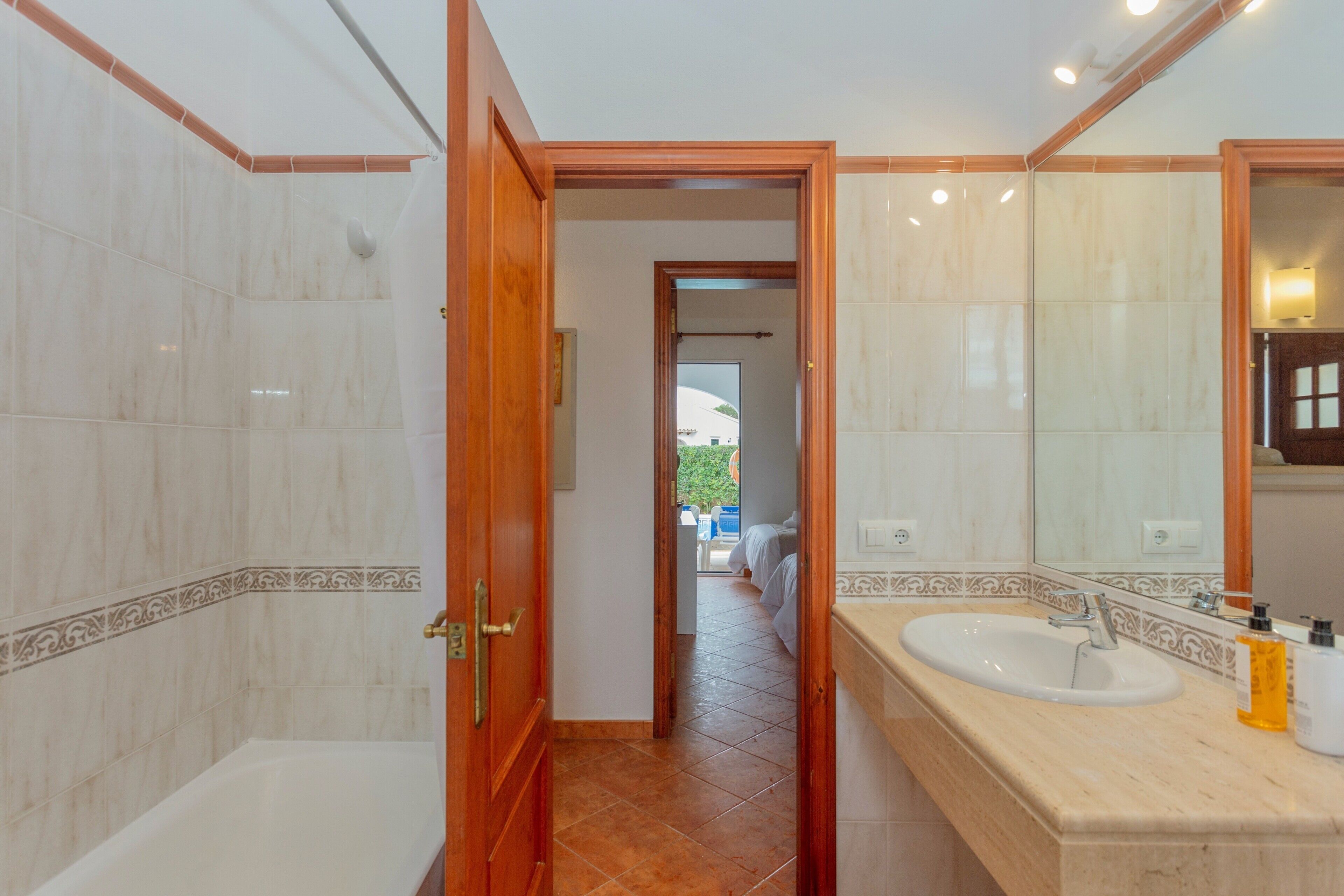 Un baño con bañera, lavamanos y espejo.
