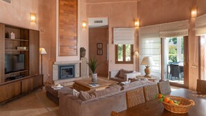 A spacious living area with a fireplace, comfortable seating, and a television. - Villa Lila with Private Pool, Garden and Wi-Fi (Benalup Casas Viejas)