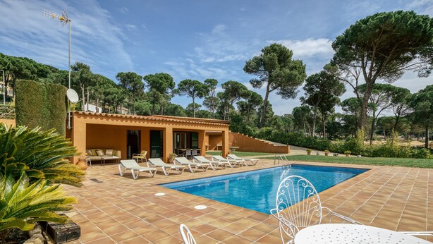 A swimming pool with lounge chairs and a small building with a door and windows. - House with Private Pool, Mountain Views, and Wi-Fi in Begur (Begur)