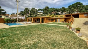 A residential property with a swimming pool, a grassy yard, and a patio area with outdoor furniture. - House with Private Pool, Mountain Views, and Wi-Fi in Begur (Begur)