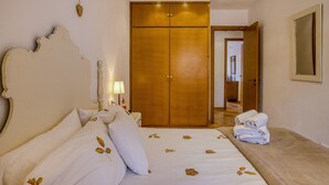A bedroom with a large bed, a wardrobe, a bedside table with a lamp, and a door leading to another room. - House with Private Pool, Mountain Views, and Wi-Fi in Begur (Begur)