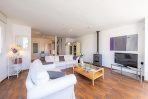 A modern living room with a sofa, coffee table, TV, and fireplace.