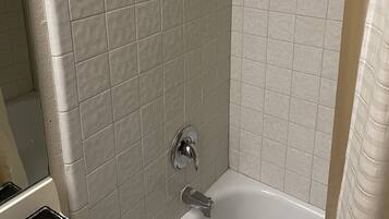 Tina con regadera, toallas, jabón, papel de baño