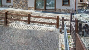 A multi-story wooden building with balconies, stone facade, and a clear sky. - Apartment 'Sant'Antoni Plan' with Mountain View, Shared Terrace and Wi-Fi (Livigno)