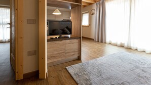An open wooden cabinet with a television, a light fixture, and a window with curtains. - Apartment 'Sant'Antoni Plan' with Mountain View, Shared Terrace and Wi-Fi (Livigno)