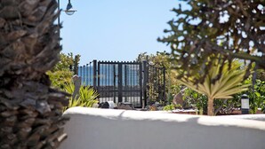 A gated area with a metal fence, a street lamp, and a clear blue sky.
