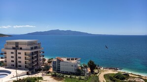 Un hôtel situé sur la côte, offrant une vue sur la mer et avec une montagne en arrière-plan.