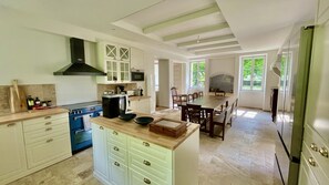 A spacious kitchen with a large island, built-in appliances, and ample natural light from large windows.