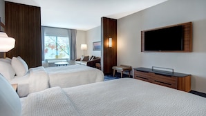 A hotel room with two beds, a desk, a TV, and a window with a view of trees. - Fairfield by Marriott Inn & Suites Rochester Hills (Rochester)