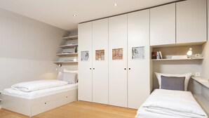 Een moderne slaapkamer met een bed, een bureau en ingebouwde opbergruimte.
