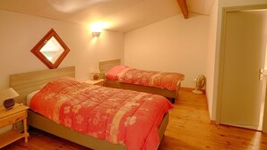 A bedroom with two beds, a nightstand, a lamp, a mirror, and a door. - Garden-Level Apartment, 3 Rooms, 6 Guests, Near Liscia Beach (Calcatoggio)
