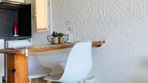 Una cocina moderna con armarios blancos, encimera de madera y una silla blanca.