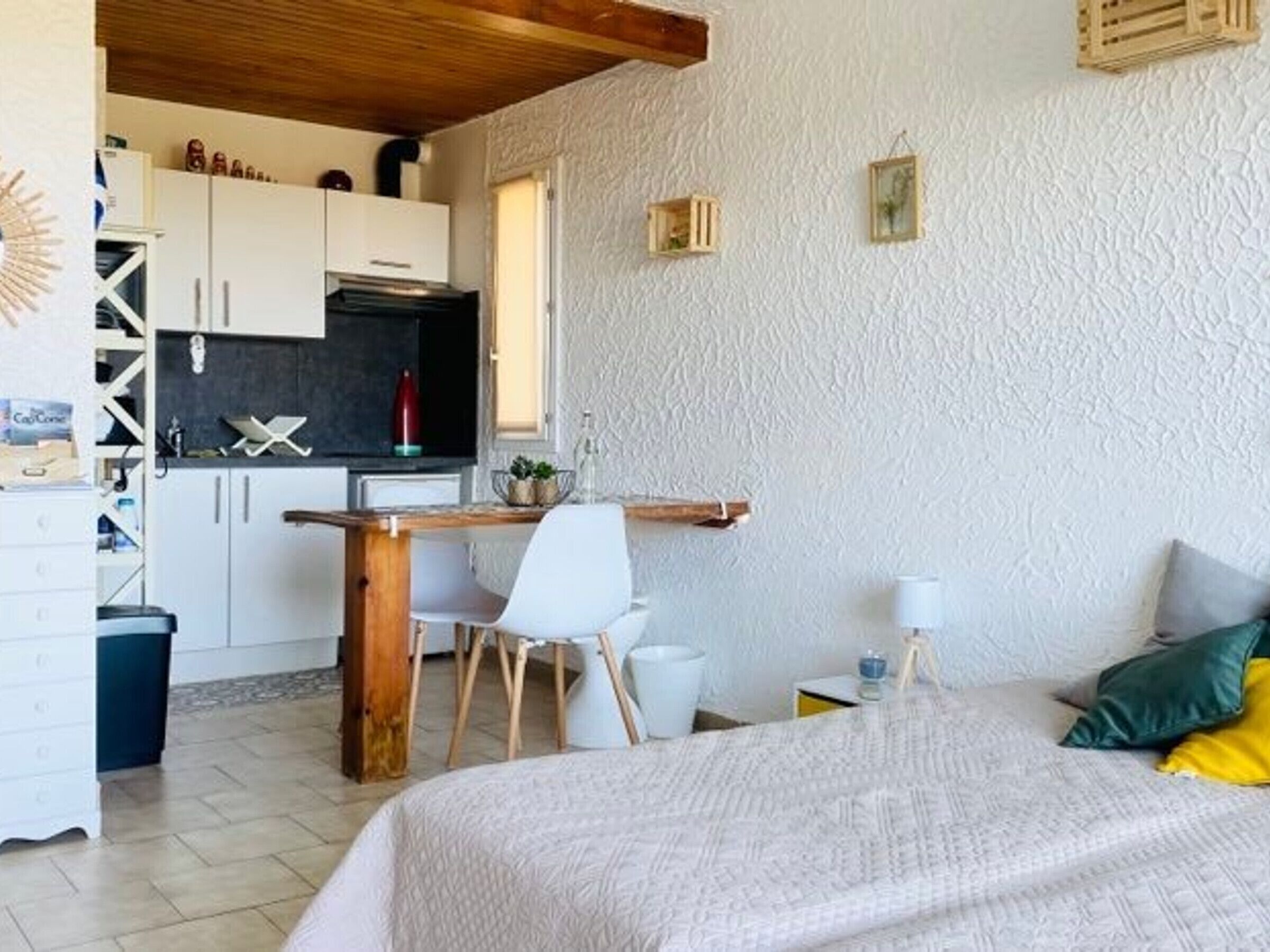 Ein Schlafzimmer mit Bett, Schreibtisch und einer Küchenzeile.