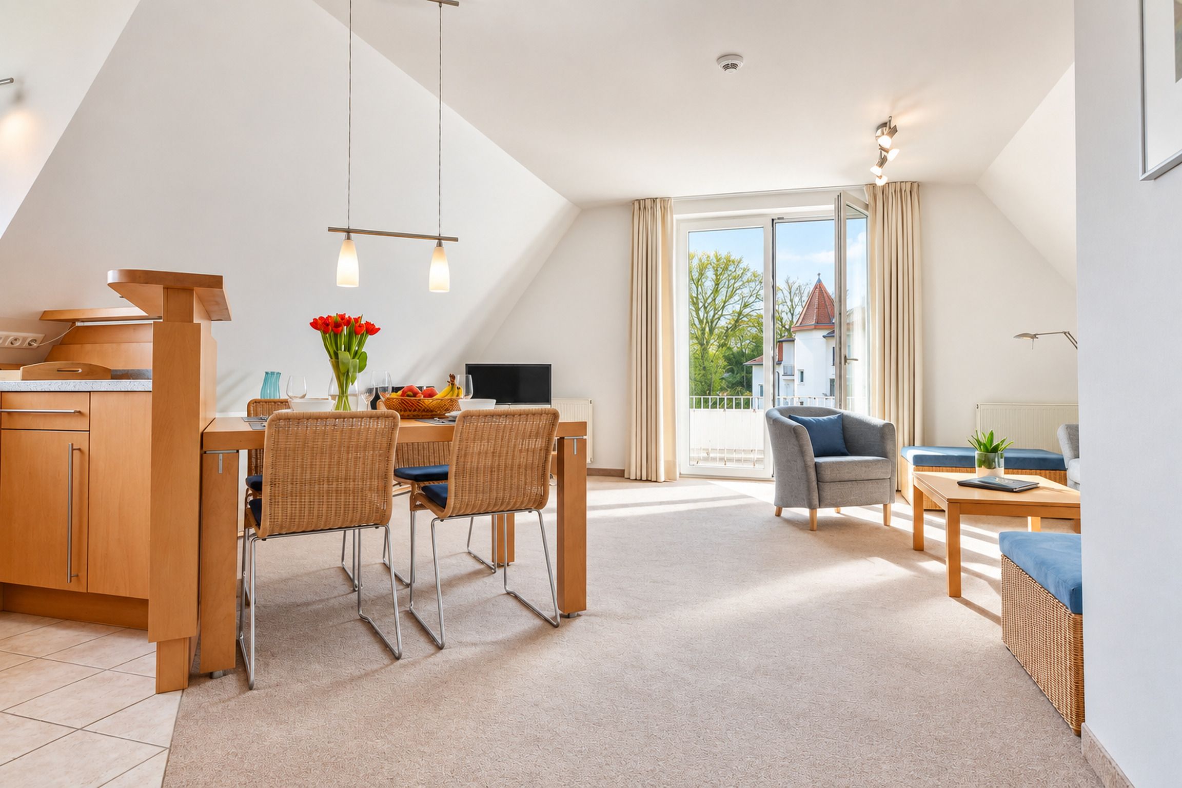 A modern interior with a dining area, kitchen, and a balcony with a view.