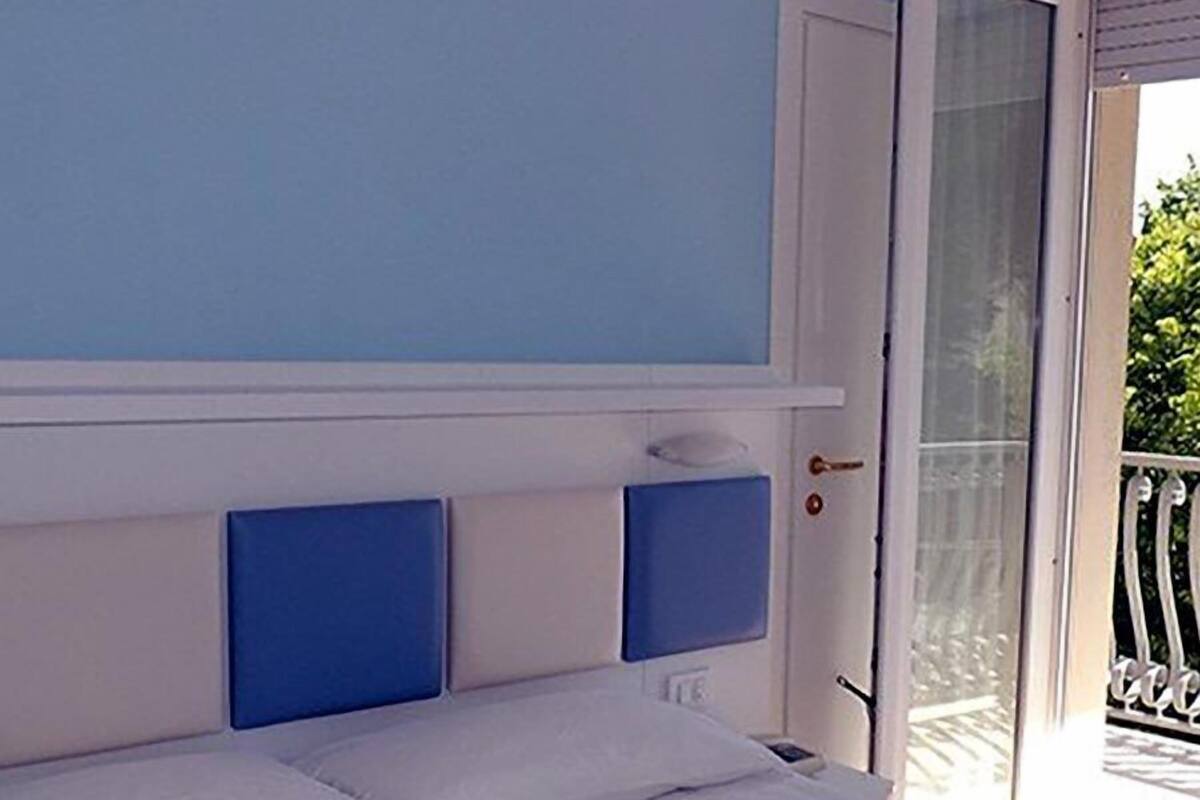 Une chambre à coucher avec un lit, une porte et une vue sur l’extérieur.