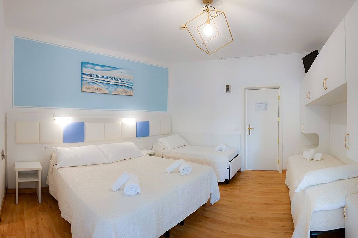 Une chambre d’hôtel avec deux lits, une petite table et une porte.