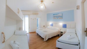 A hotel room with three beds, wooden flooring, and a painting on the wall. - Hotel Gioiosa (Cesenatico)