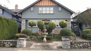 A building with a stone facade, a sign reading "Frutchel Manor Inn Suites," and a stone fountain in the center.