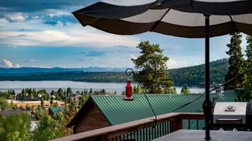 A balcony with a view of a lake, mountains, and a red lantern.