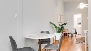 Un comedor moderno con una mesa redonda, sillas tapizadas en gris y una planta en maceta.