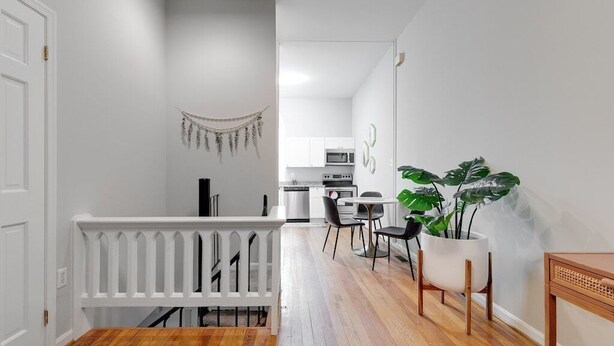 Una cocina moderna con gabinetes blancos, un microondas y una estufa.