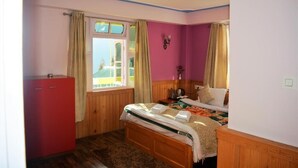 Un dormitorio con una cama de madera, un armario rojo y una ventana con cortinas.
