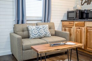 Relax in this inviting living space with a sofa, small table, and kitchenette.