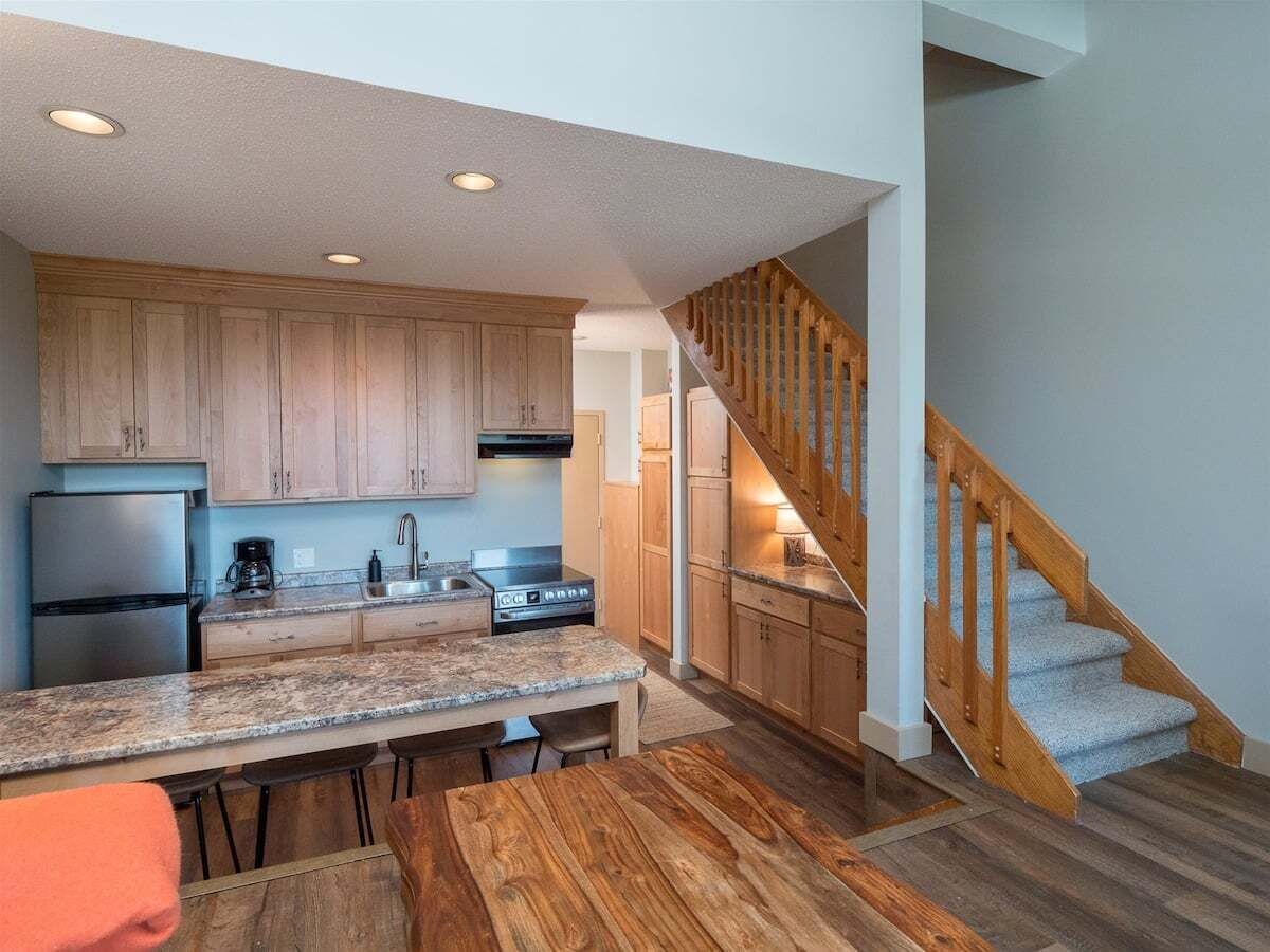 A modern kitchen with wooden cabinets, a granite countertop, and a built-in stove.