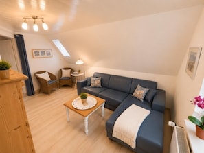 Living area - The Wellenreiter vacation apartment offers maritime comfort with a view of the dyke, plenty of space for families and a private terrace with a large garden. (Wangerland)
