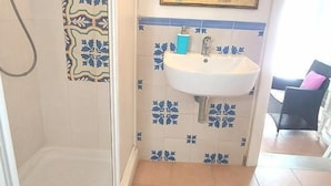 A bathroom with a shower, a sink, and a mirror.