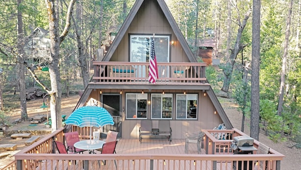 Een chalet met terras, buitenmeubilair en een vlag.
