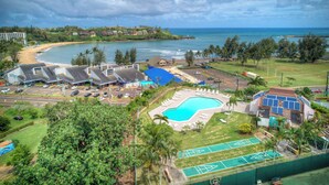 Ein Resort mit Schwimmbad, Tennisplätzen und Blick auf den Strand.