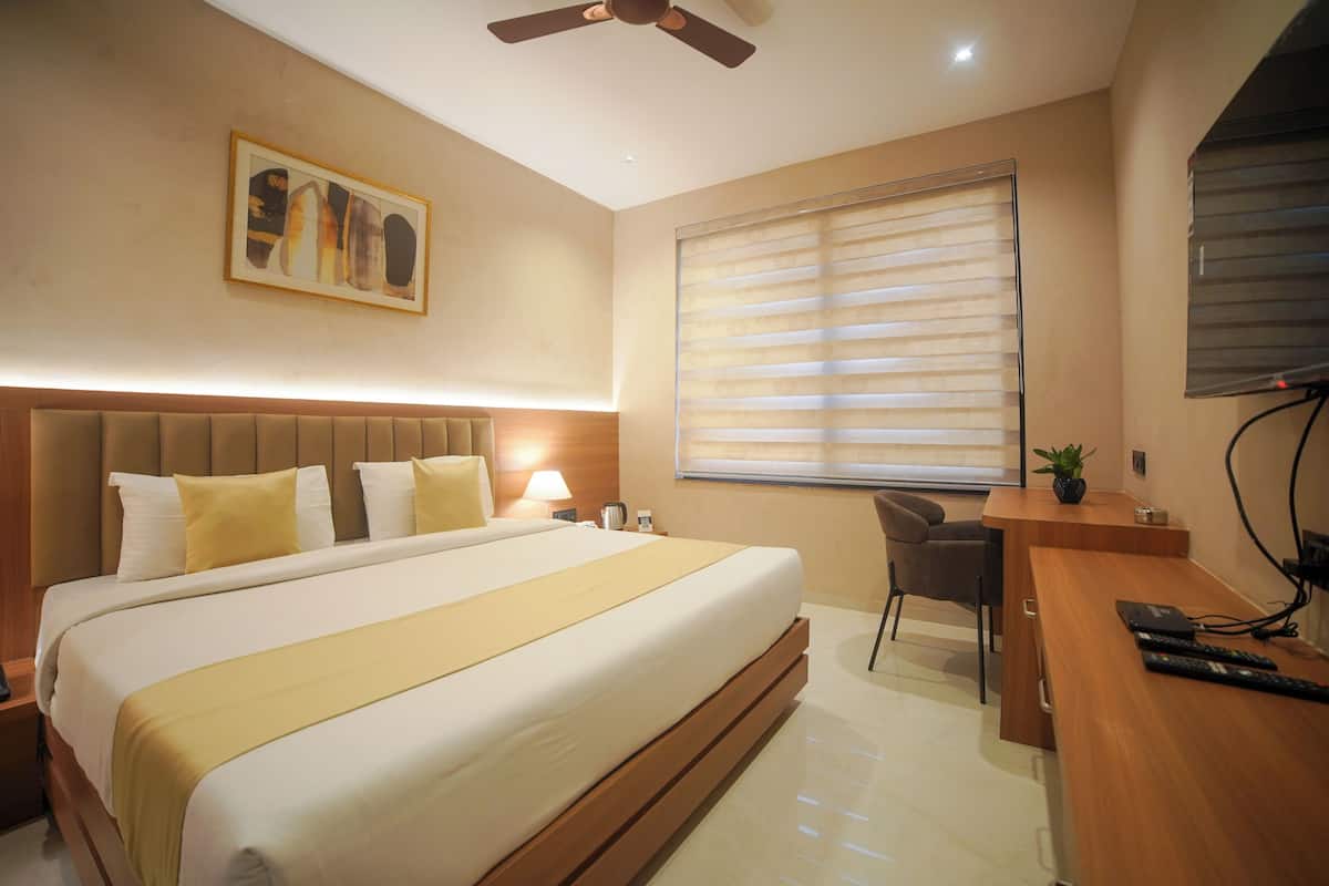 Una camera d'albergo con un letto grande, una scrivania e una sedia.