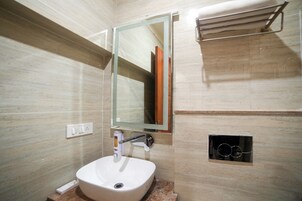 A bathroom with a white sink, a mirror, and a towel rack.