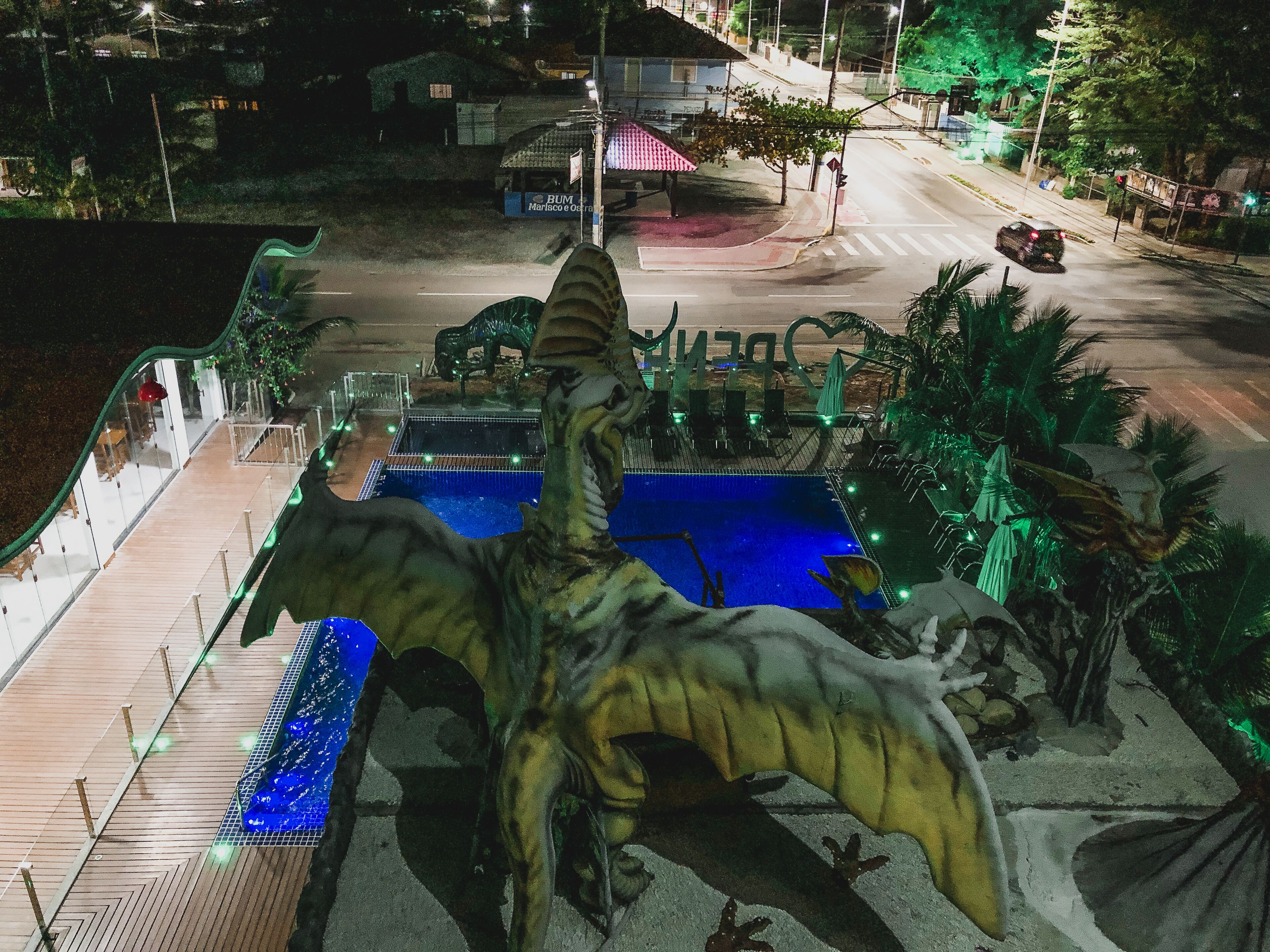 A dinosaur-themed outdoor area with a pool and seating.