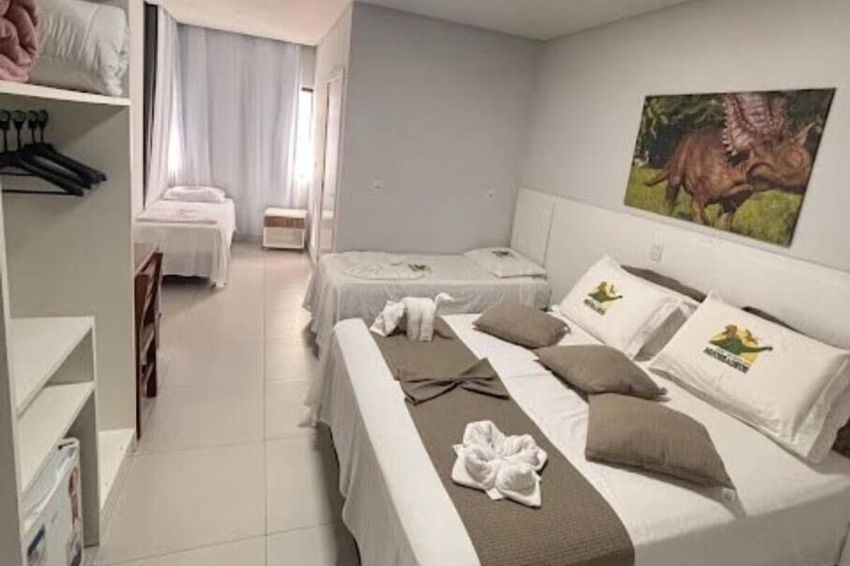 Una habitación de hotel con dos camas, un armario y un cuadro en la pared.