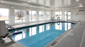 Une piscine intérieure avec des marquages bien visibles, des fenêtres et un panneau indiquant qu’il est interdit de plonger.