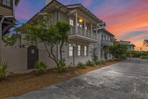 A two-story house with a balcony, a garage, and a driveway.